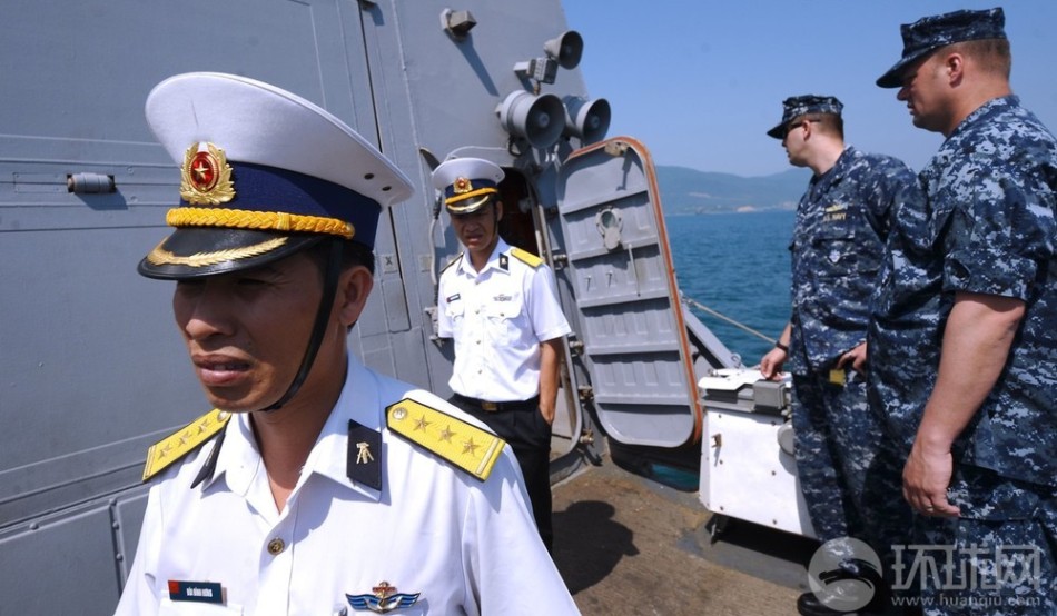 越南海军军官走出美国海军查菲号驱逐舰的船舱后面部表情复杂