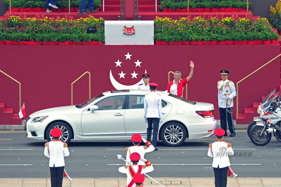 新加坡总理李显龙(挥手者)抵达新加坡旧政府大厦大草场出席国庆庆典