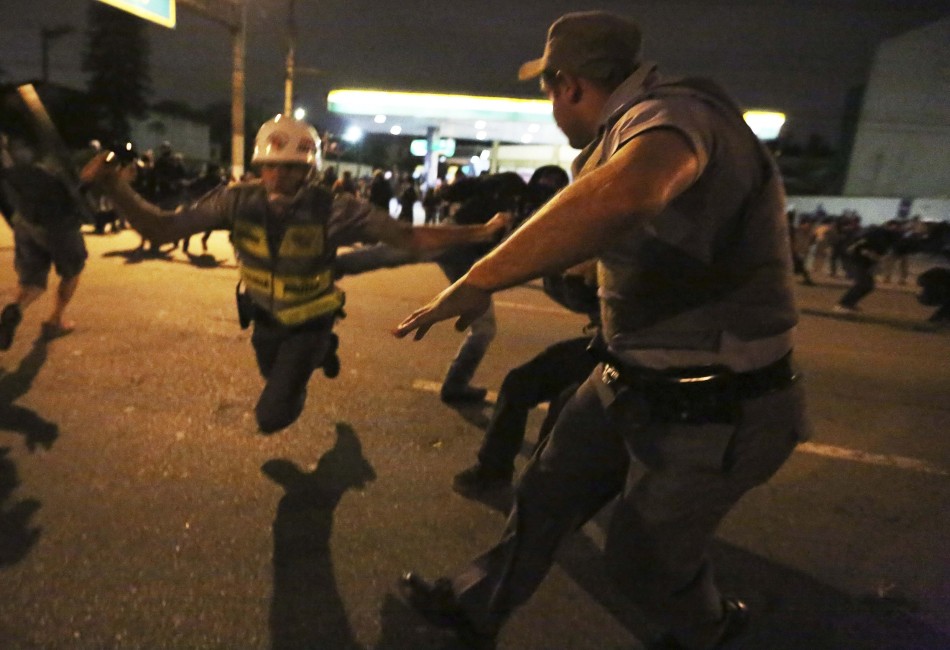 一位暴力抗议者将警察踢倒