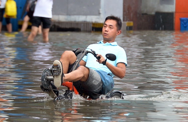 汉口解放大道单洞门路段因暴雨严重渍水,一名男子在渍水中骑水上