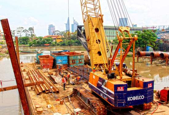 　一号城铁高架桥线路段途径11个站，图中是连接第2郡和第9郡的曲折桥附近的施工场地。（图片来源：越南媒体）