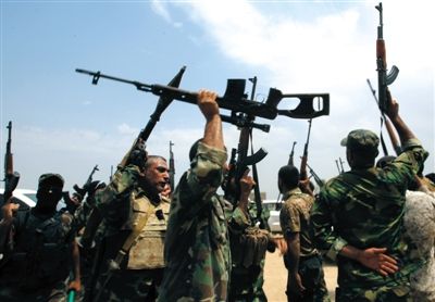 8月18日，巴格达附近，抗击极端武装的伊拉克什叶派和平旅战士挥舞着武器。