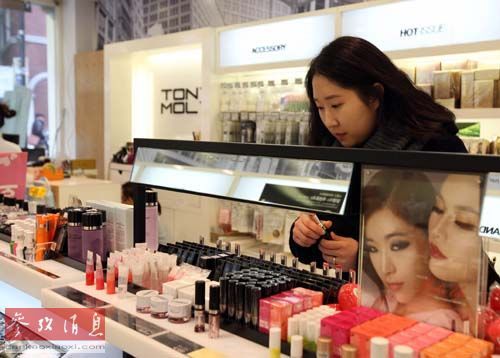 资料图：一名女子在韩国首尔明洞购物区选购化妆品。新华社记者何璐璐摄