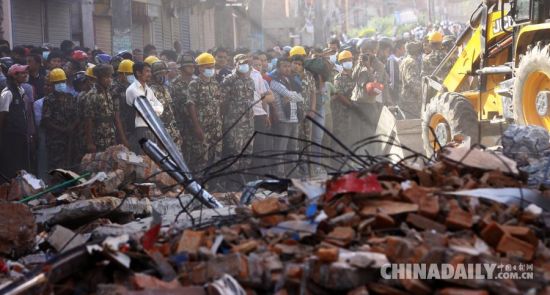 　5月12日，在尼泊尔加德满都，人们站在建筑物废墟旁。 据中国地震台网测定，尼泊尔北京时间5月12日15时5分，发生7.5级地震。 新华社发（苏尼尔·夏尔马摄）