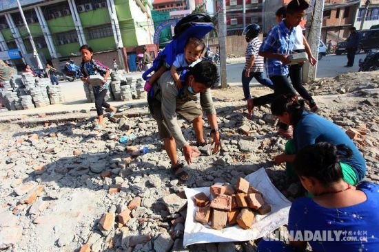 5月12日，在尼泊尔加德满都，一名家长背着孩子转移至安全地带。 据中国地震台网测定，尼泊尔北京时间5月12日15时5分，发生7.5级地震。 新华社发(苏尼尔·夏尔马摄)