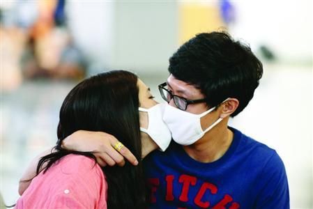 6月7日，釜山，一对戴着口罩的情侣在火车站内亲吻。