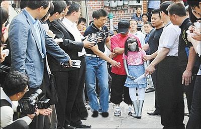 2010年6月，涉嫌性侵小学女生的韩国男子金某，在警方的羁押下回到作案现场，用假人演示作案经过。