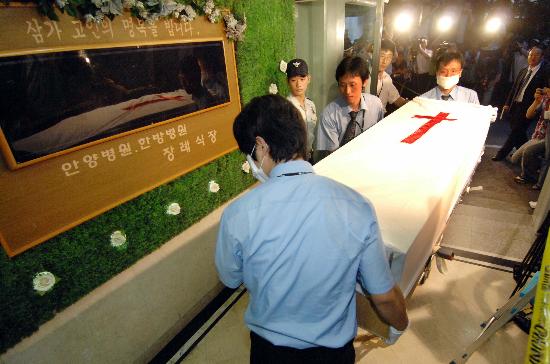 图文:工作人员准备将裴衡圭的遗体放入冰柜