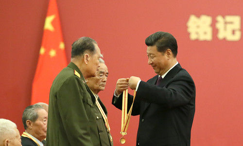习近平向抗战老兵授纪念章