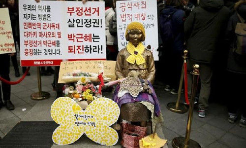 30日，韩国民众在日本大使馆前的慰安妇雕像旁示威。（图片来源：路透社） 