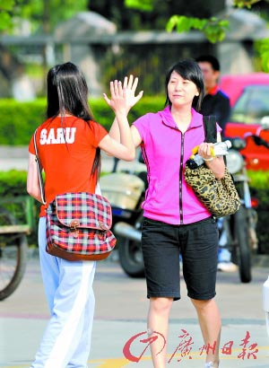 家长击掌鼓励考生。