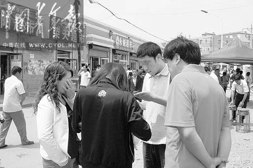 6月8日中午，全国统一高考吉林省松原市扶余县第三中学考点门外，一名考生（左二）在与场外发送答案的青年男子（右二）交流。这位女生抱怨自己收到的选择题答案不完整，对男子说：“你是从17题给我发进来的。” 本报记者 张国摄