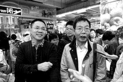 陈生(左）和陆步轩在向大家介绍壹号土猪。