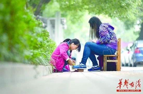 11月18日，长沙市黄土岭公交车站附近，杨婷正在给一名顾客擦鞋。