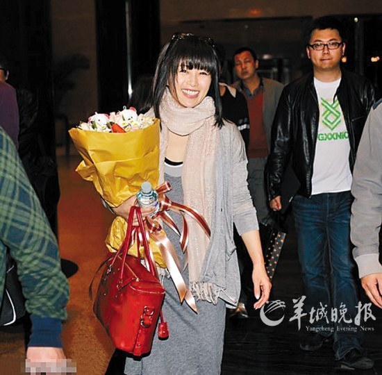 　　酒井法子手捧鲜花离开中国