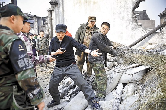 　　张艺谋(中)在片场亲身示范