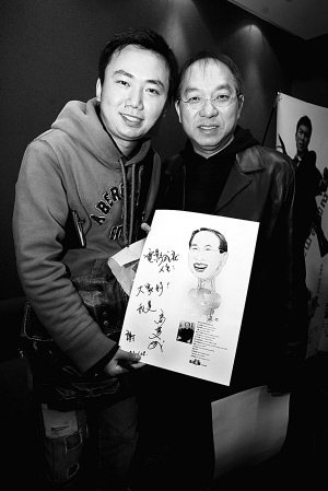 马楚成接受晨报记者送上的漫画，并在漫画上题词“电影成就人生”。