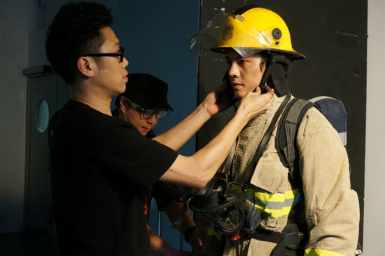 导演郭子健为陈伟霆戴消防帽