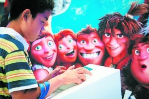 小朋友在《疯狂原始人》背景板前查看作品演示。该片是东方梦工厂首度代理发行的梦工厂动画电影，在国内取得了近4亿元的良好票房。早报记者 兰卉 图