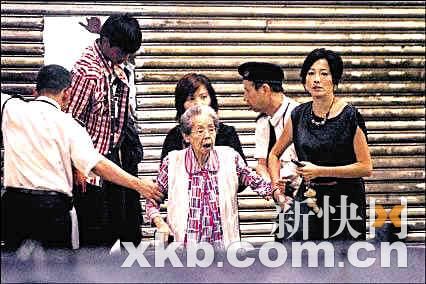 Wendy(右)和儿子（左二）搀扶谭老太离开。