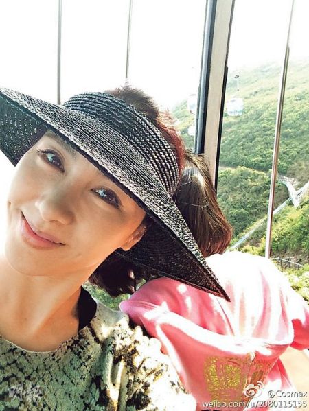 黎姿在缆车内玩自拍，还露出甜美笑容。