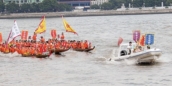 美女乘坐的快艇在前领路，后面的各艘龙舟奋勇争先