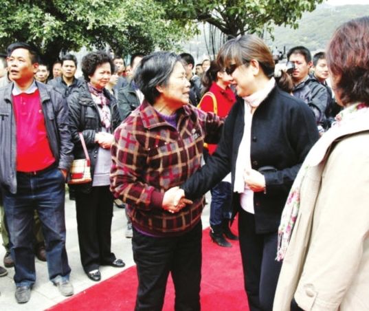 陈凯歌妹妹陈凯燕(中)与当地乡亲握手