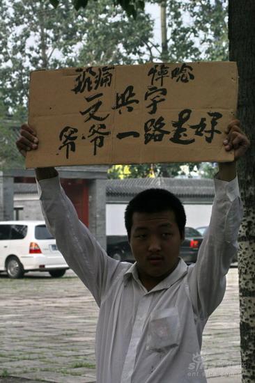 市民高举悼念标语新浪娱乐讯 文兴宇追悼会及遗体告别式于3日上午9时