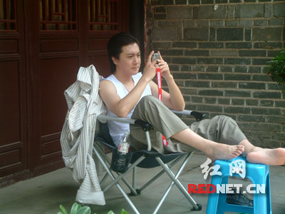 挤在拍戏的空隙，迟帅脱下上衣坐在一边专情地发短信