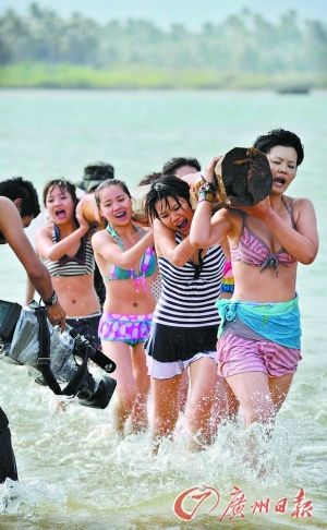 美女们扛着原木在海滩奔跑，这是保镖训练的项目之一。 