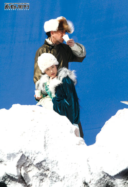 “胡一刀夫妇”站在假雪山上喝饮料