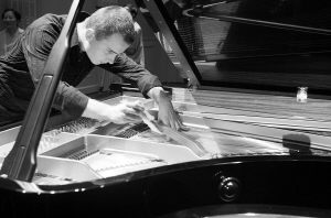 哲帕尼克认真地摆放木夹的位置，以便能让钢琴发出奇妙的声音。