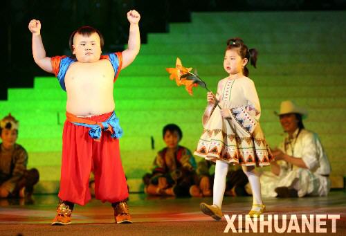 8月4日，“五彩传说”呼伦贝尔草原儿童合唱团6岁的鄂温克族成员奥成（左）正在和同伴演出。