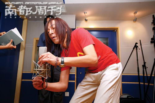 摄影师不小心碰了摆好的麦克风，制作人颜仲坤重新摆好。