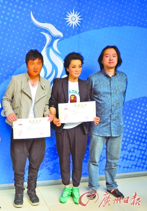 孙楠、毛阿敏昨天被亚组委授予“亚运歌手”。右为捞仔。邵权达摄 