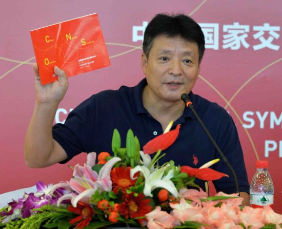 主持人田少明手举新乐季画册介绍演出