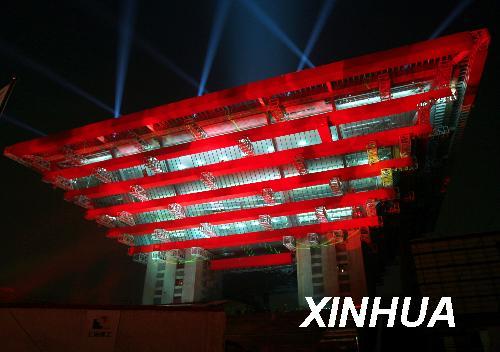 6月22日晚拍摄的“红妆中国馆”。被称为“东方之冠”的中国馆是整个上海世博园区体量最大的展馆之一，其“外衣”的“中国红”具有很强的象征意义。经过色彩专家和设计团队一年多的“红色追寻之旅”，中国馆最终选用了7种不同的红色为中国馆调色，其中“外衣”用了4种红色。4种红色，有民俗、传统、时尚、现代之分。将于8月份全部穿上“红衣”的中国馆，届时将向世人传达喜庆、吉祥、欢乐、和谐的情感。新华社记者 任珑 摄