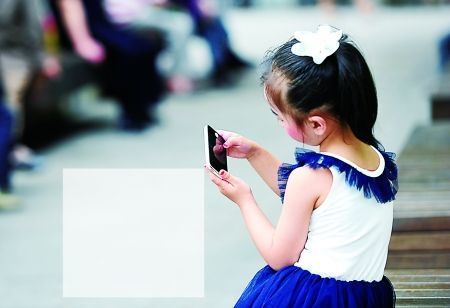 沙坪坝区，一个小女孩在用手机玩游戏。