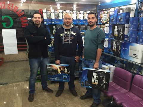 在“伊拉克游戏中心”，两名刚买下《美国末日》同捆版PS4的玩家与店主合影。