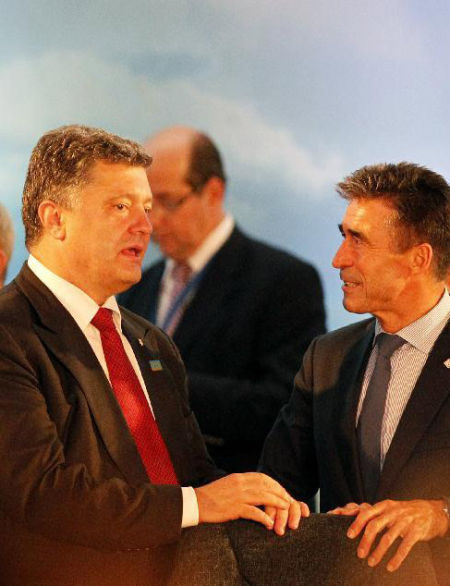 资料图：9月4日，在英国威尔士纽波特，乌克兰总统波罗申科（前左）与北约秘书长拉斯穆森在北约峰会关于乌克兰局势的专门会议前交流。