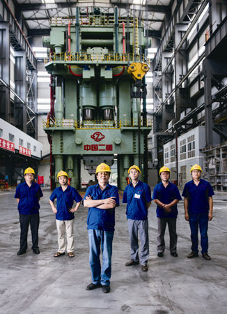 资料图：二重集团副总工程师陈晓慈（左三）与几十位工程师建造了世界最大的8万吨模锻压机。