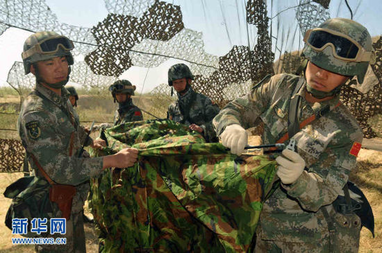 官兵们在伪装网下搭设三人帐篷