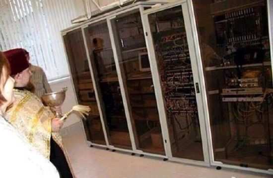 资料图：俄罗斯已经把希望寄托到了耶稣身上，图为俄罗斯东正教牧师正往中央银行的服务器上撒圣水，祈祷卢布不要下跌