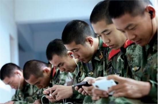 资料图：某部战士们在休息时看手机