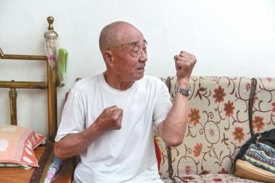 87岁的钟信正在描述和日寇拼刺刀的场景。京华时报记者 赵思衡 摄