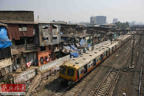 一辆火车经过印度孟买的贫民窟。新华社记者郑焕松摄