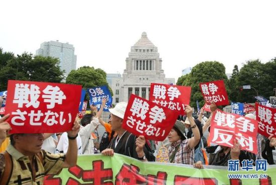 2015年7月14日，日本民众在国会外集会，手举标语牌，高喊口号示威，抗议新安保法。 