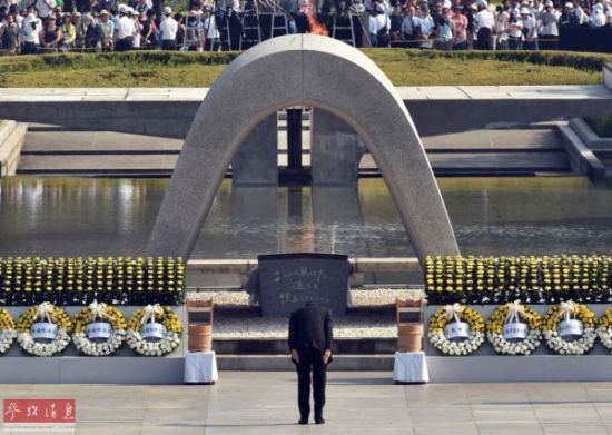 8月6日，在日本广岛和平纪念公园，日本首相安倍晋三（中）在参加原子弹爆炸70周年纪念活动时，向遇难者纪念碑鞠躬。