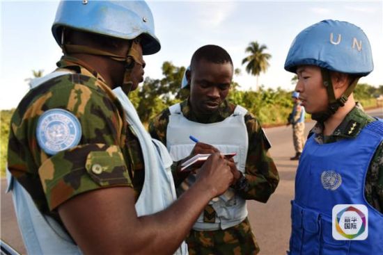  一名中国维和军官（右）与负责护卫的尼日利亚军人沟通任务安排。 