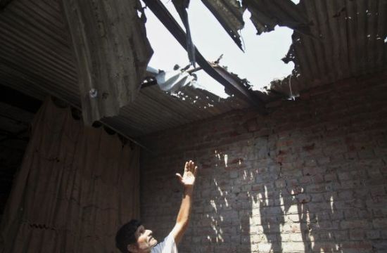 8月28日，在克什米尔查谟附近的一个村庄，一名当地居民展示受损的房屋。美联社